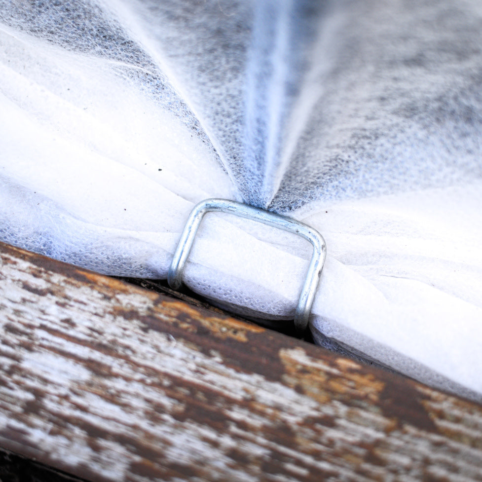 Broche recourbée qui tient une toile sur un lit de culture.