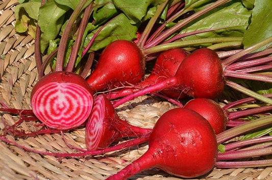 Betteraves rouges aux feuilles vertes et dedans blanc et rose.